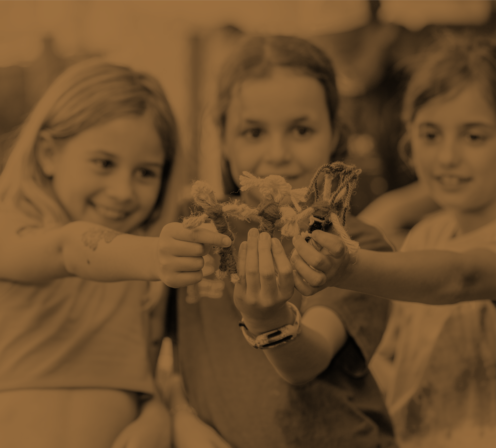 Tres niñas sosteniendo juntas una cuerda, actividad de cooperación en La Granja de los Cuentos.